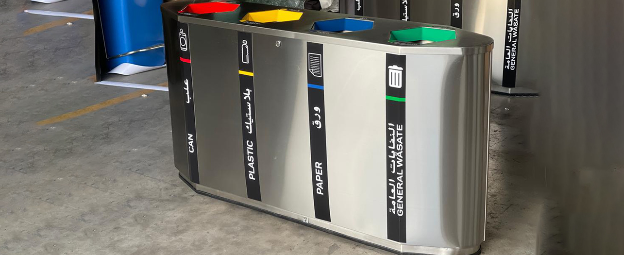 Recycling station with labeled bins for cans, plastic, paper, and general waste