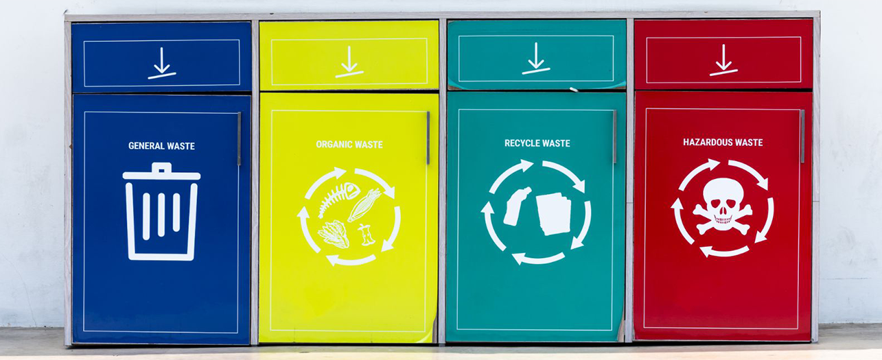 Color-coded waste bins with recycling labels