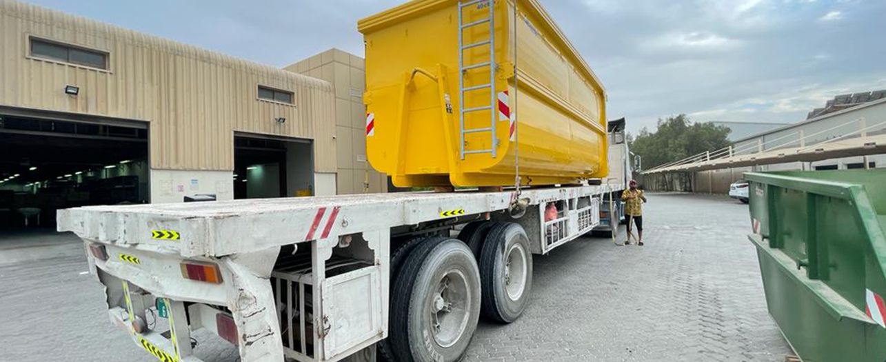Yellow Ro-Ro container loaded on truck for bulk waste disposal