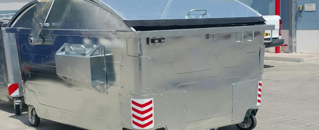 Large galvanized steel dumpster bin with wheels outdoors.